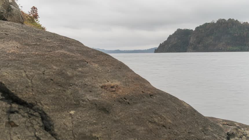 Ocean waves are moving towards the coast of the rocky landscape