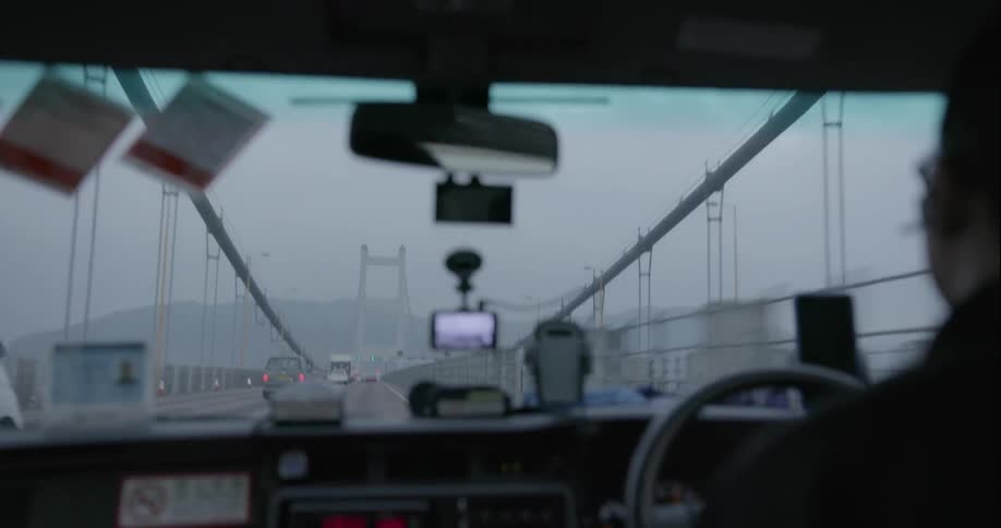 A man drives a car over a bridge