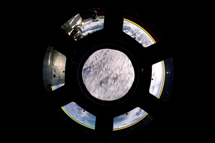 Time lapse of a view of the earth from space framed by the windows of the copula located on the international space station