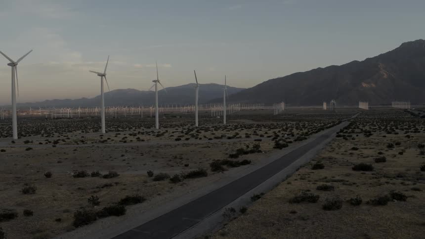 Tall windmills spinning in a field
