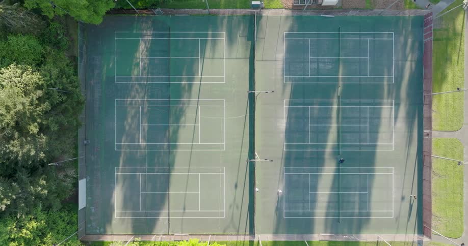 Two people play on one of six available tennis courts in a park