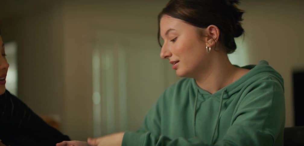 A student is studying and talking with another woman