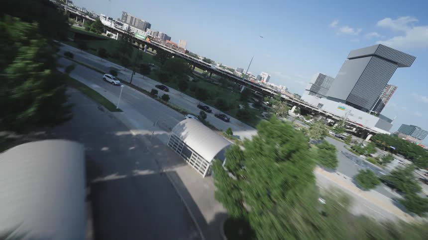 Cars driving on streets surrounding urban Dallas in summer time