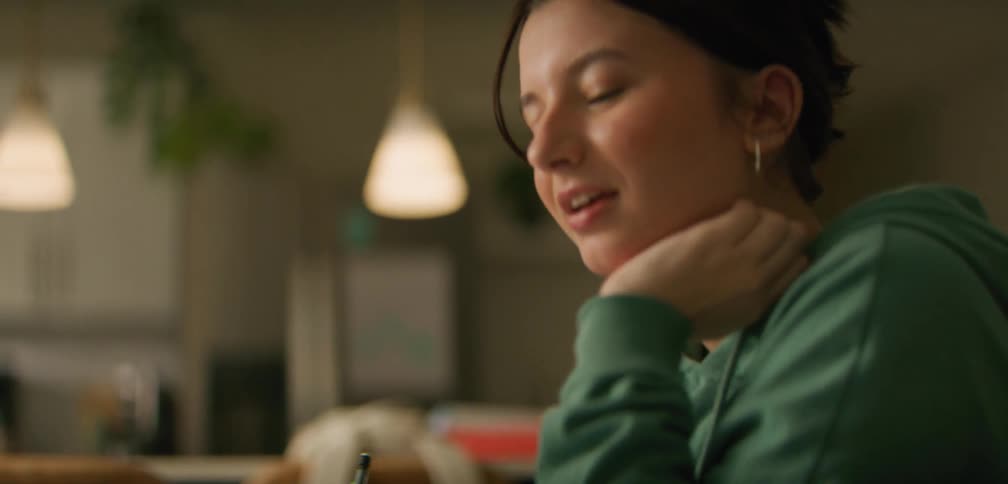 A young woman is sitting at a table and doing homework