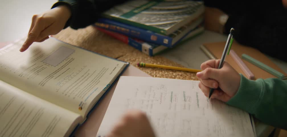A person helping a girl with math homework