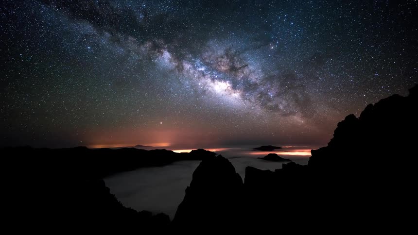 Time lapse of the night sky and sunrise over the mountains at night