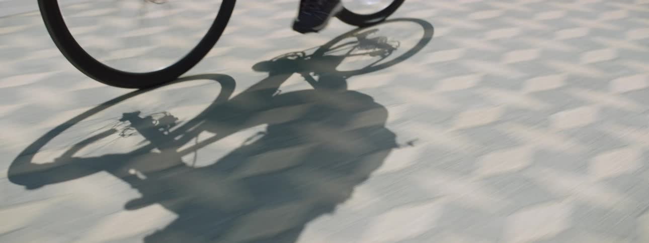 A person is riding a bicycle on pavement outdoors