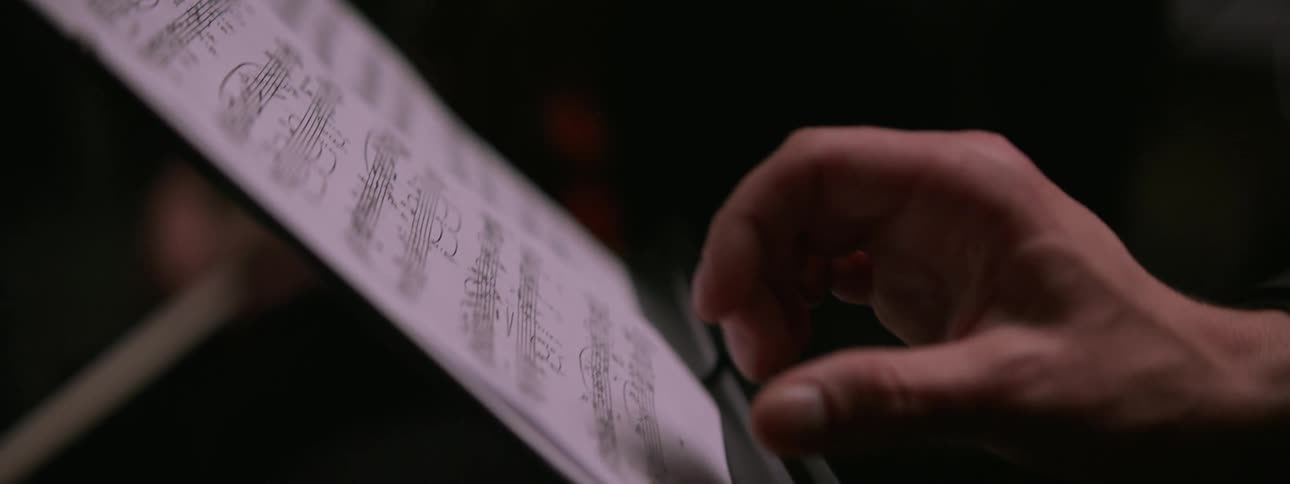 Male musician looks through sheet music