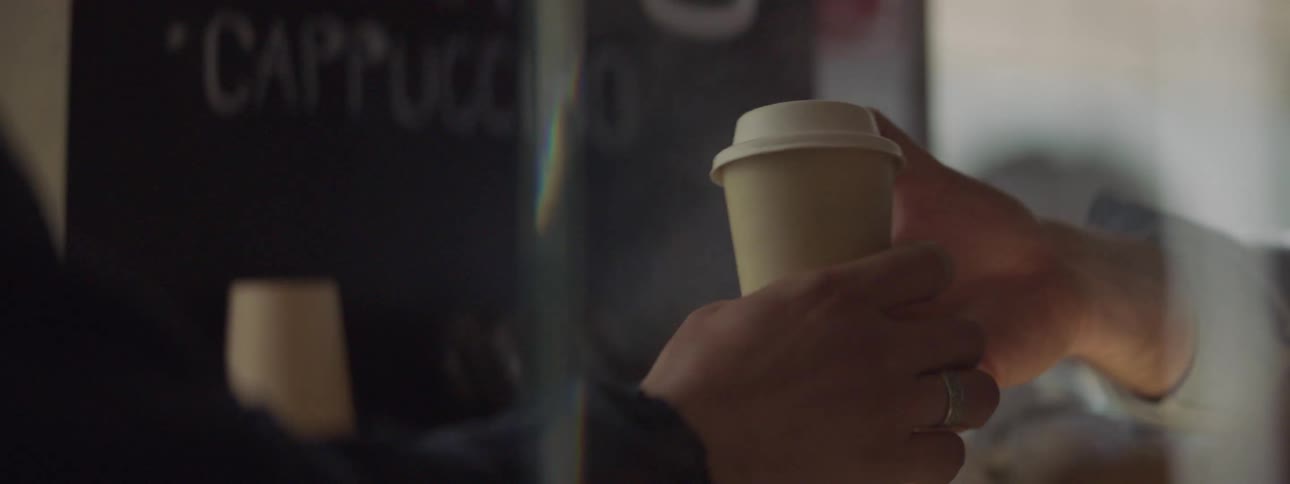 A customer is handed a cup of coffee