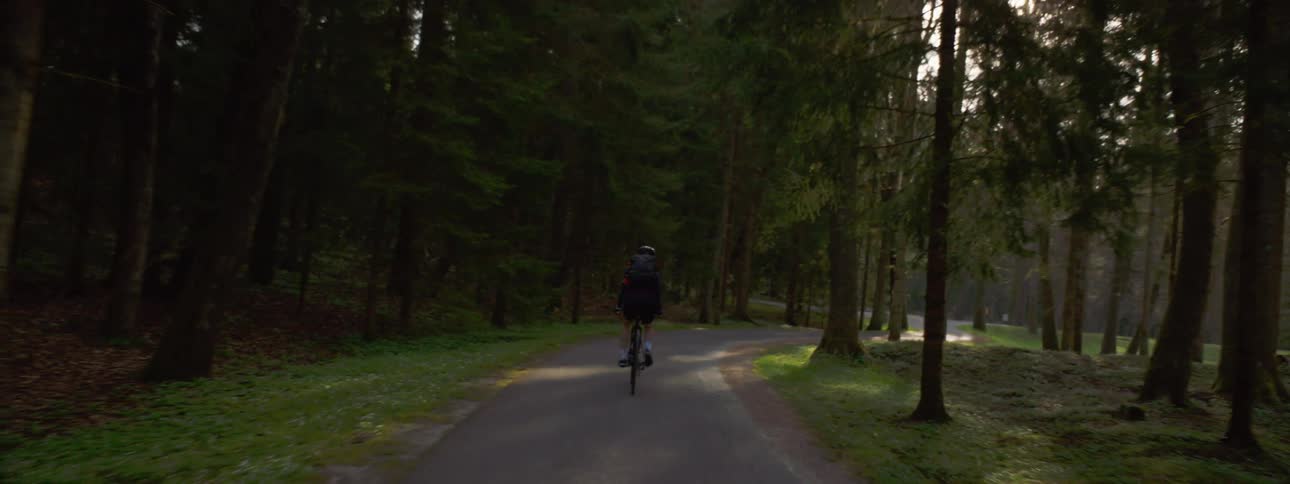 A person is biking on trails through a park in spring