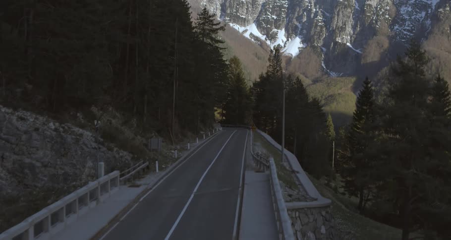 A person is riding a bike over a bridge in a rural area