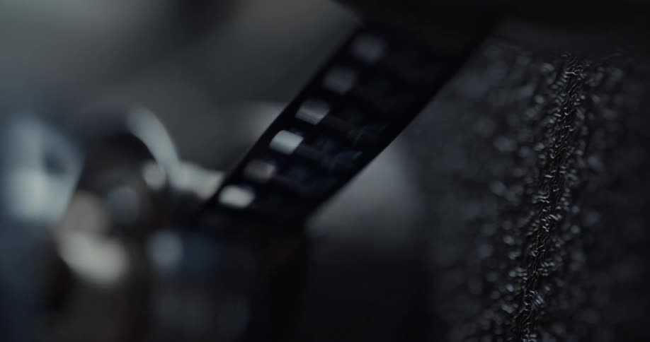 Long strip of metal with rectangular holes is fed through a spinning machine