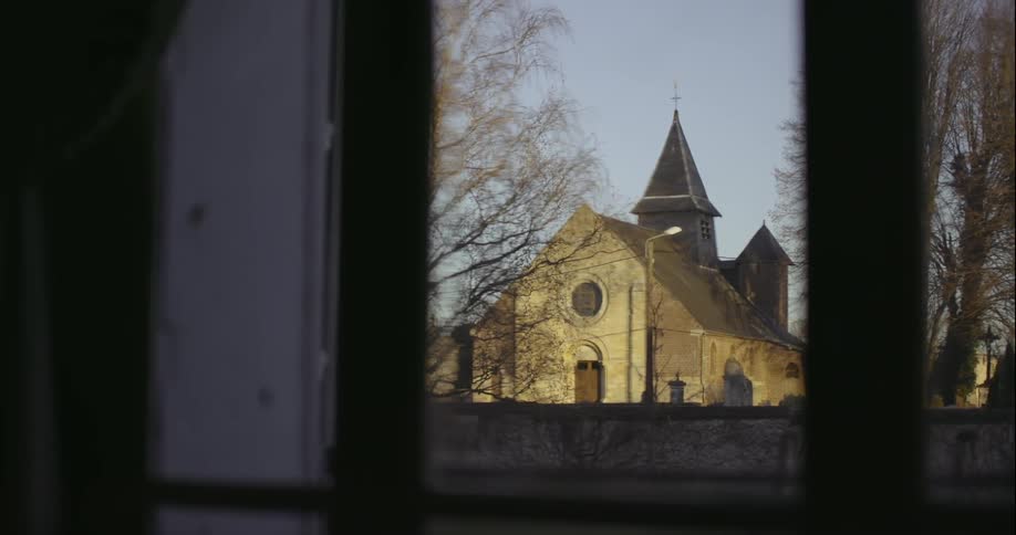 A church is lit at sunset across the way