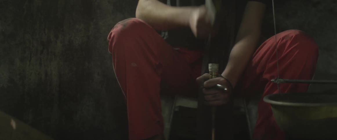 Man hammering a stick in a room