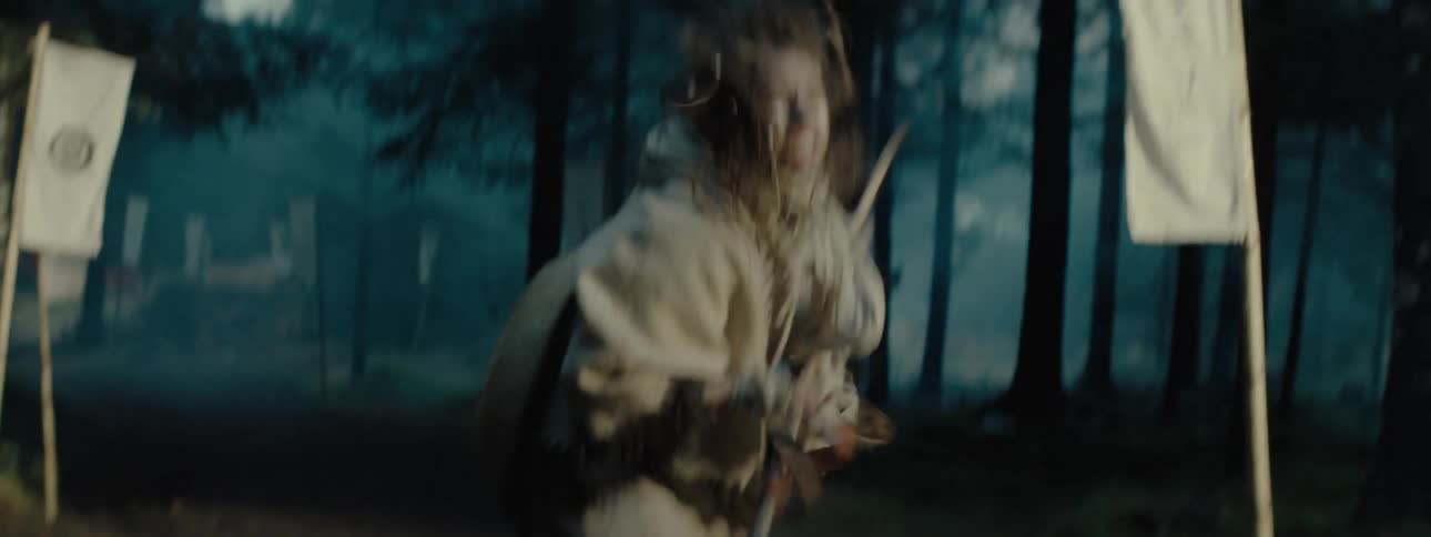A woman is swinging a stick outside