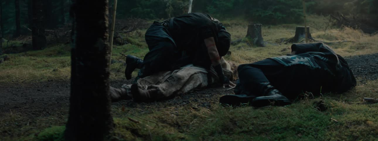 A man hugs a body on the ground