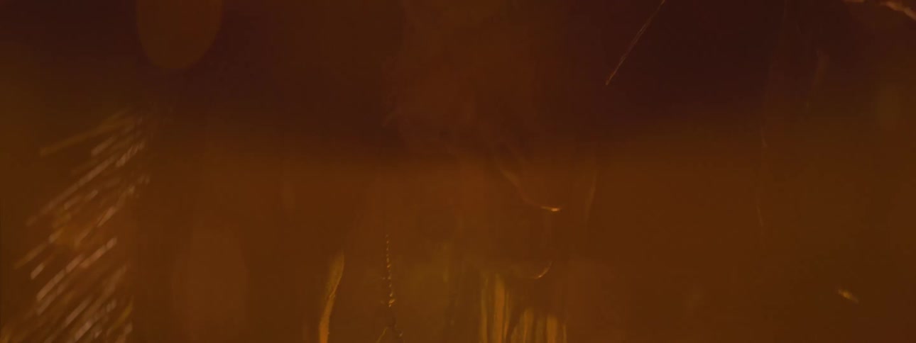 An evil looking creature raises up while being lighted a fire