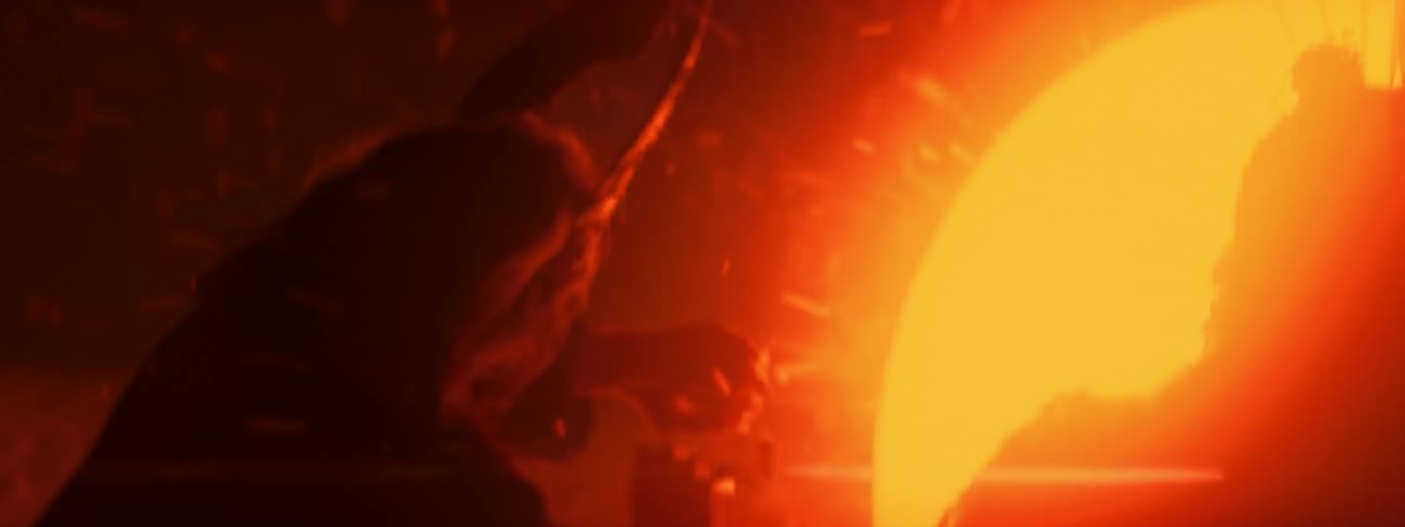 Silhouette of two people wearing ceremonial clothes shielding their faces from an exploding red orb