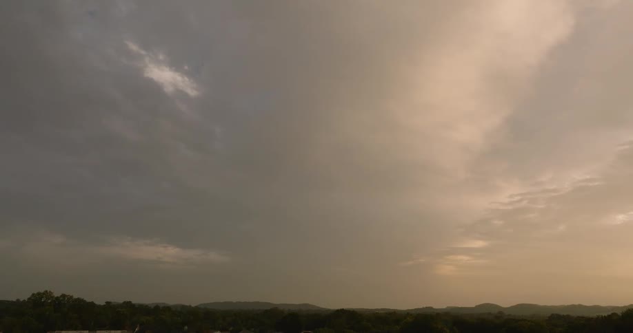 Facade of a building against a dawn sky with hills on the horizon