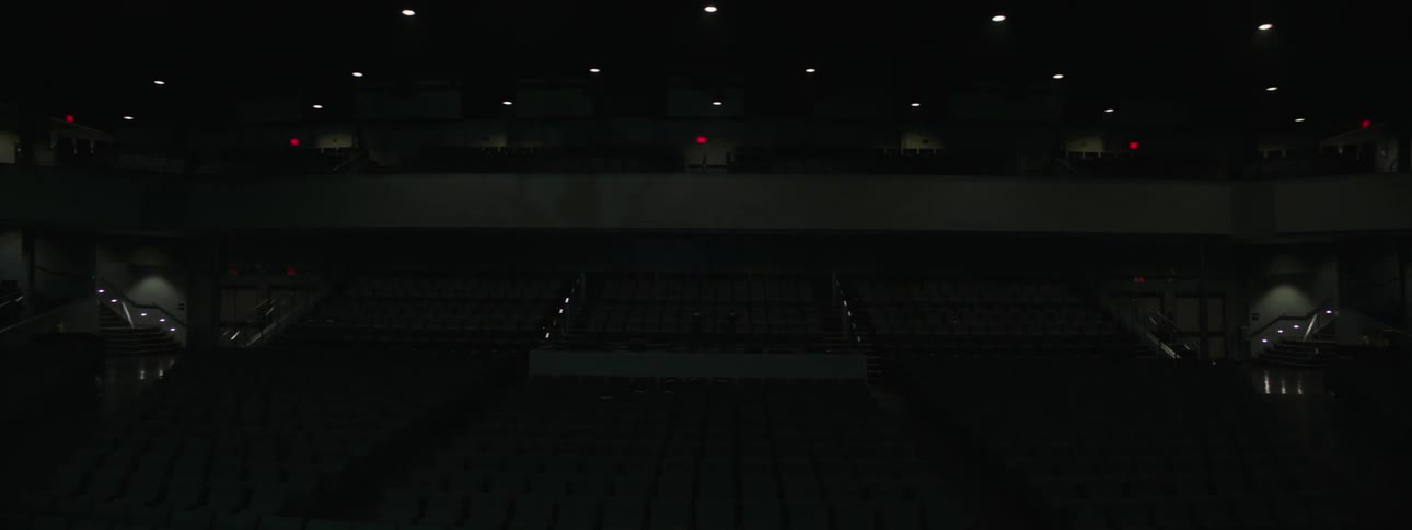 Lights shine on the ceiling of the dark theater