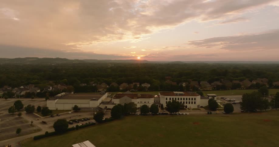 Aerial view of a residential neighborhood during sunset with closely spaced houses and trees