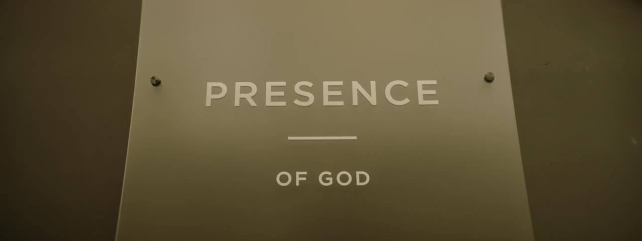 A modern church sign on a plaque inside a building