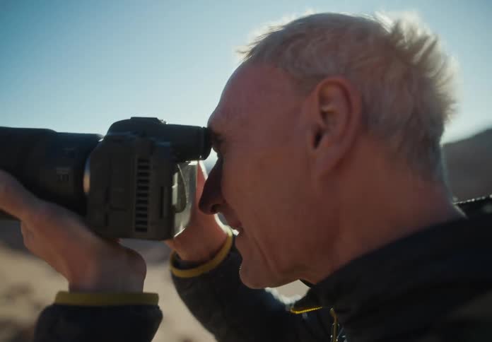 Man using a professional camera in a mountainous and desert environment