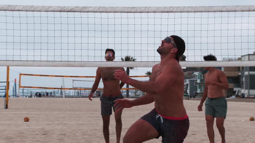 Men playing beach volleyball