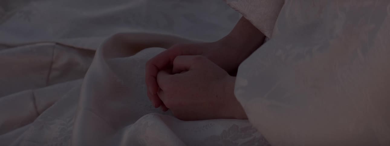 A person clasps their hands together