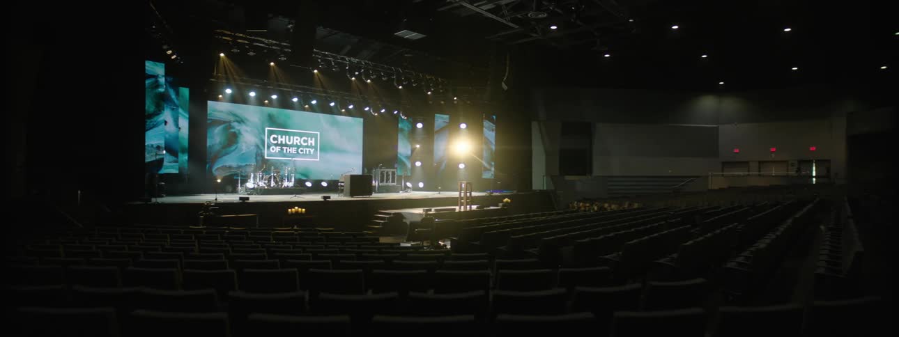 Interior of an empty auditorium with a stage illuminated with lighting