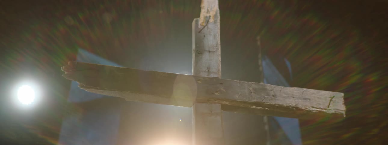 Wooden cross highlighted by lights on a stage in an auditorium