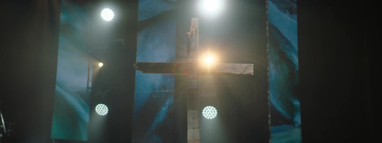 Wooden cross highlighted by lights on a stage