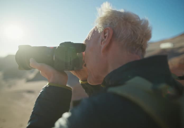 Man with a professional camera photographing in a natural environment