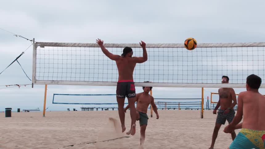 Four men playing beach volleyball