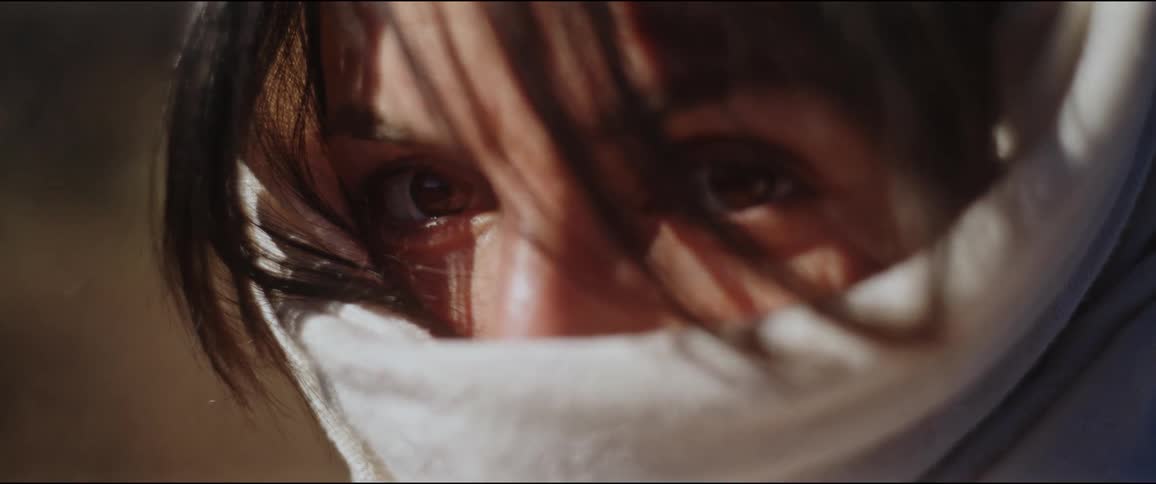 Portrait of a woman with her face covered by a cloth and her eyes are visible