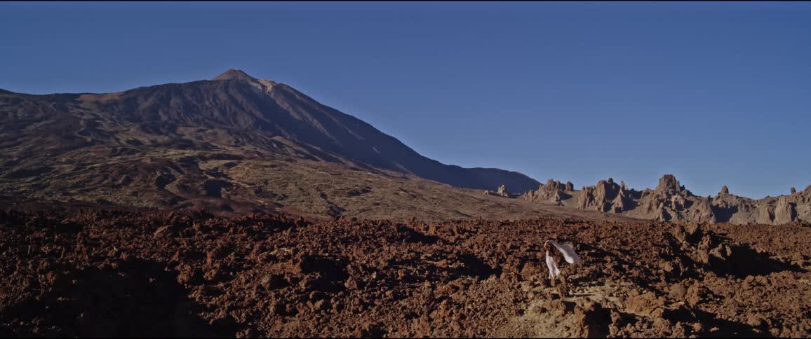A woman is standing on the windy hill