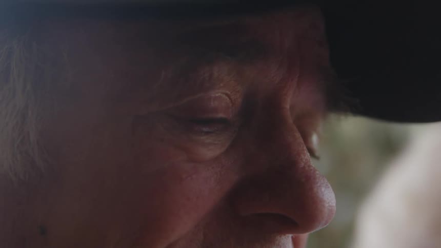 An older individuals face in closeup emphasizing the eye and skin texture