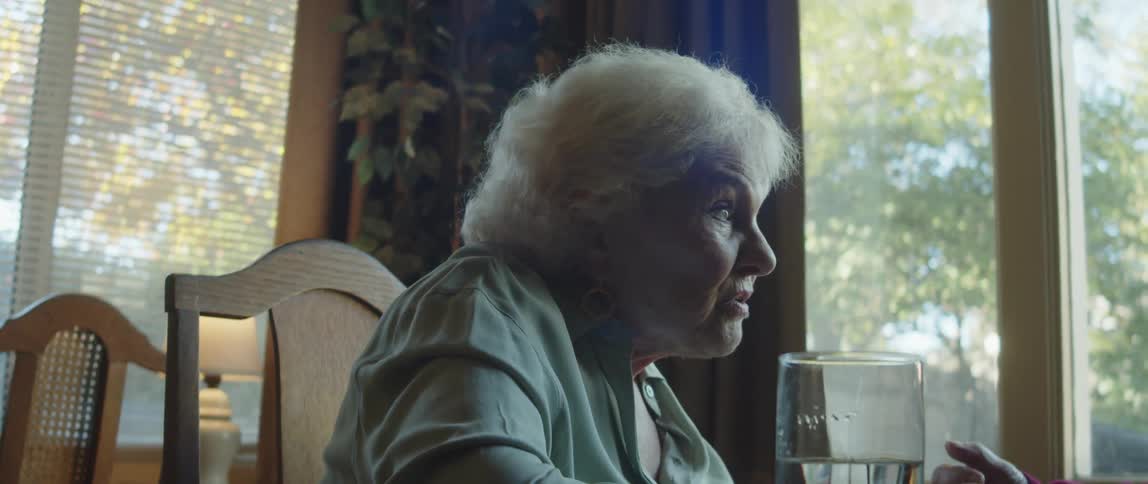 Elderly lady sitting at a table talking