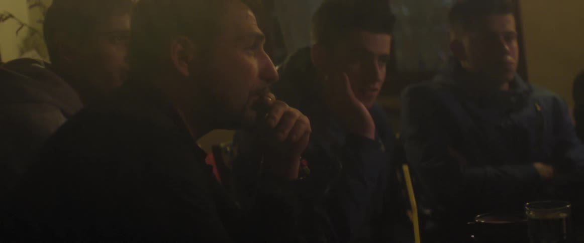 People sitting down and talking in a dark room
