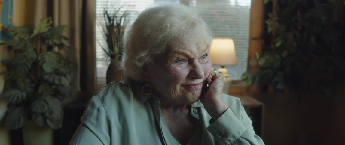 The face of an elderly woman who has her hand resting on her cheek