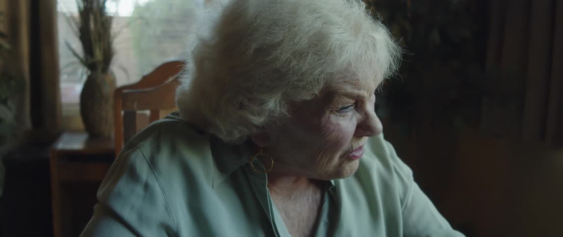 Close up of an elderly woman having a conversation at home
