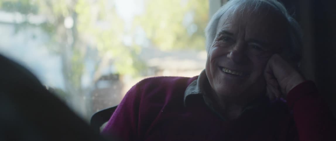 A man listens and laughs during a conversation