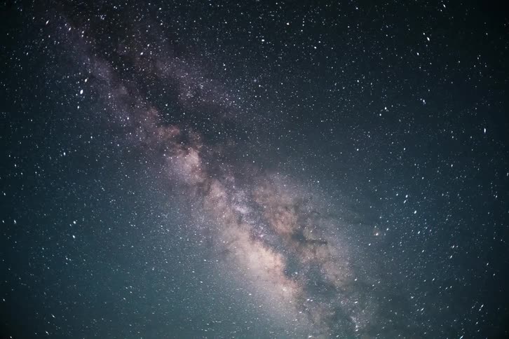 Time lapse of the moon and thin clouds and a starry night sky with dense clusters of stars