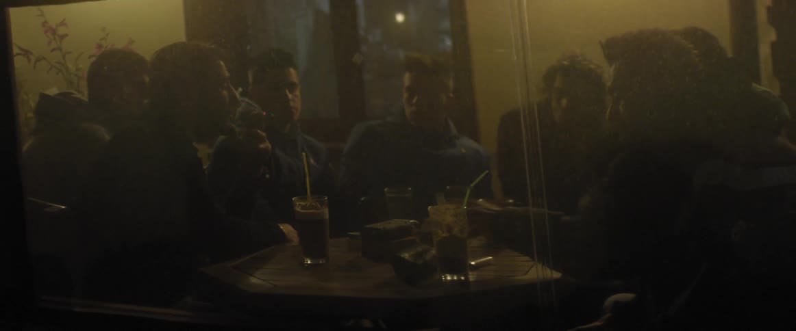 Friends sit at a table while talking and having drinks