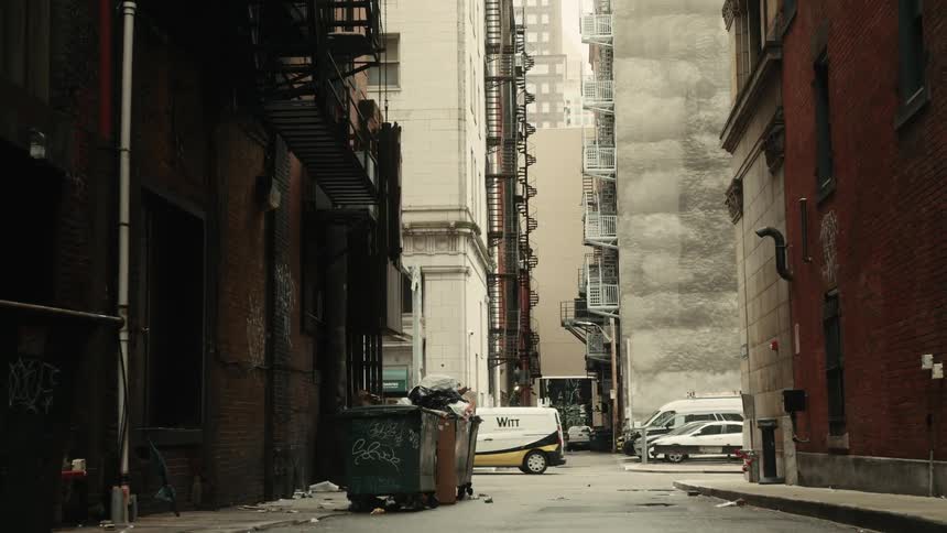 Deserted street with buildings in a metropolis and cars passing by in the background
