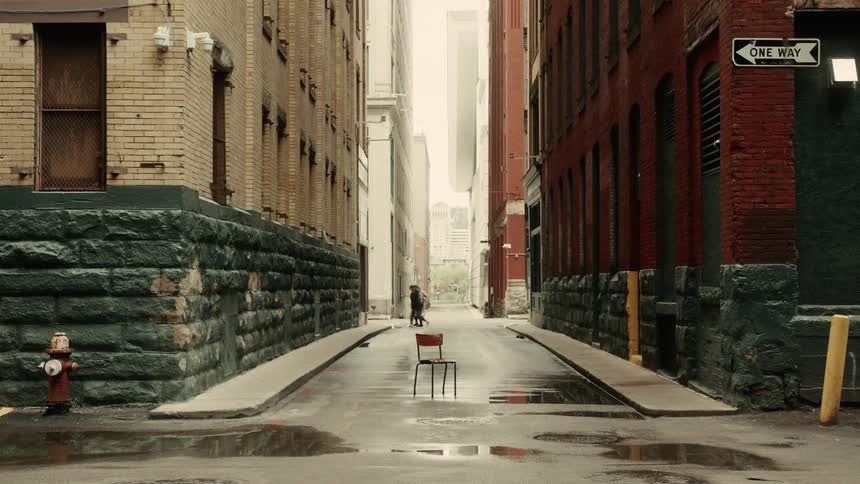 Alley with a centralized chair surrounded by buildings in a metropolis