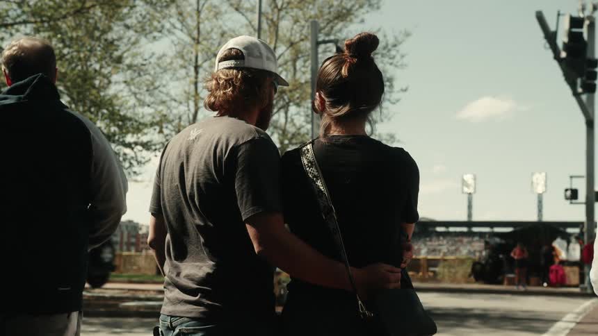 Man with his hand on his wifes waist waiting to cross the street