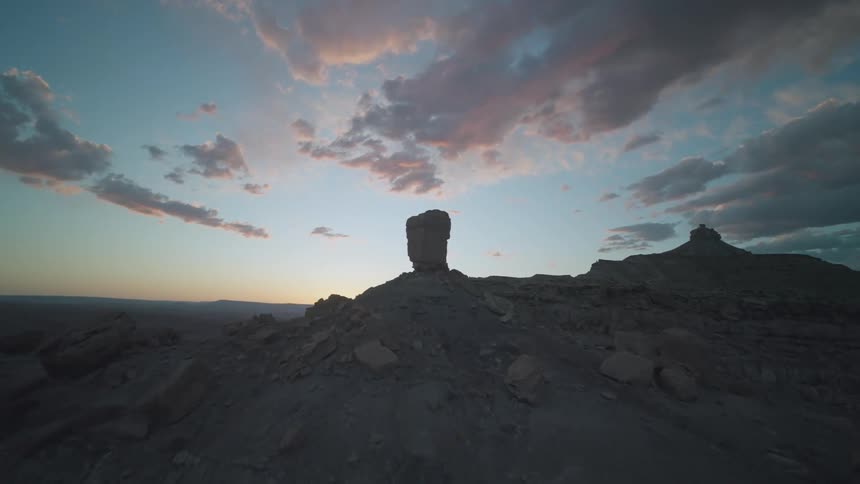 Rock formations at the top of mountains under a setting sun
