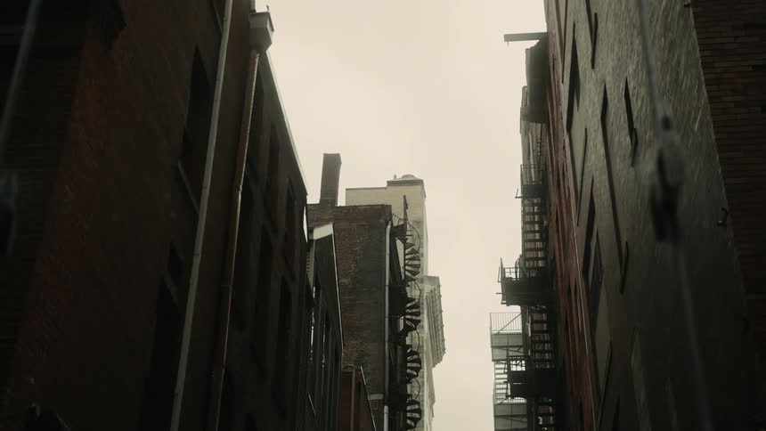 A street between some apartment buildings and the sky is white