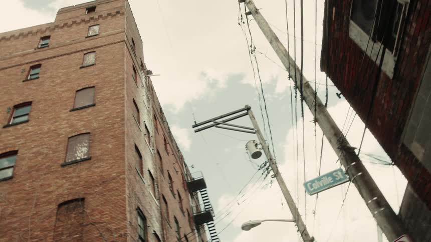 View upwards of buildings and power poles on a cloudy day
